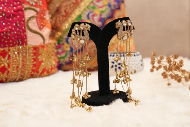 Long ethnic jhumka earrings against a festive backdrop