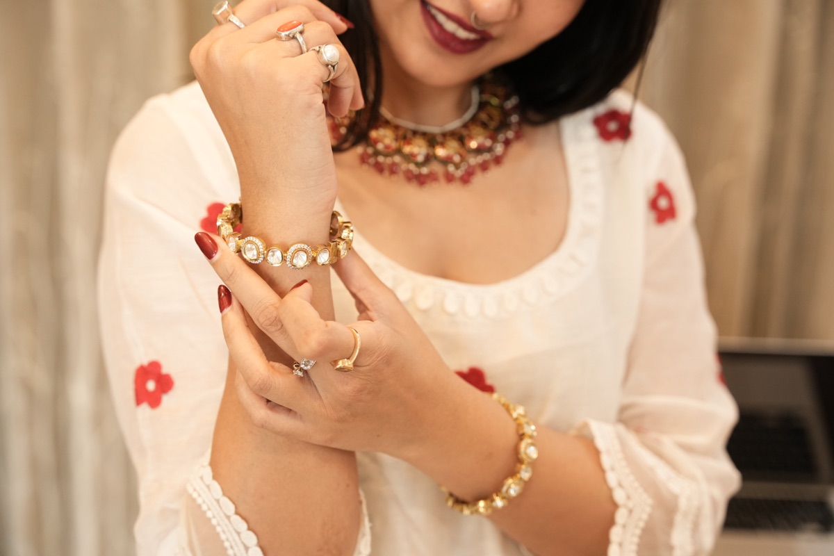 A kundan-and-pearl bracelet worn over a white kurta